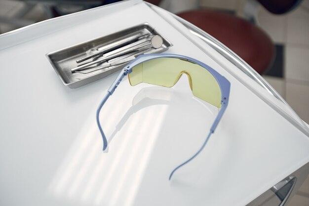 Goggles in the dentist's office.The tools lie on a tray.Preparing the dentist before admission