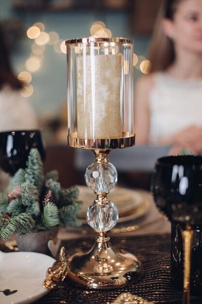 집에서 축제 테이블에 서 있는 금 촛대. 새 해 이브 개념