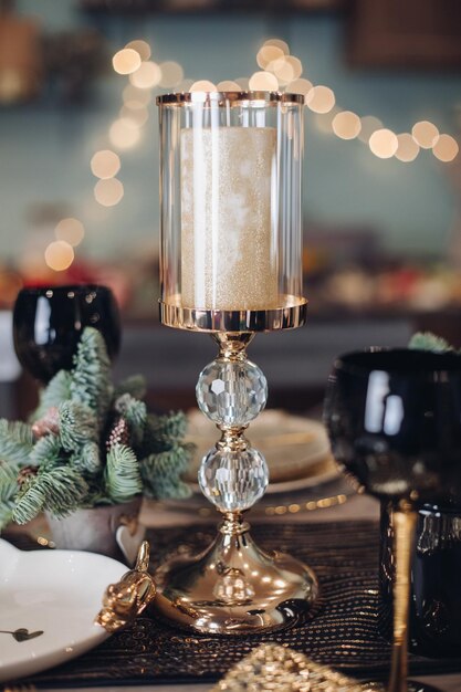 Gold candlestick standing on the festive table at home. New Year eve concept