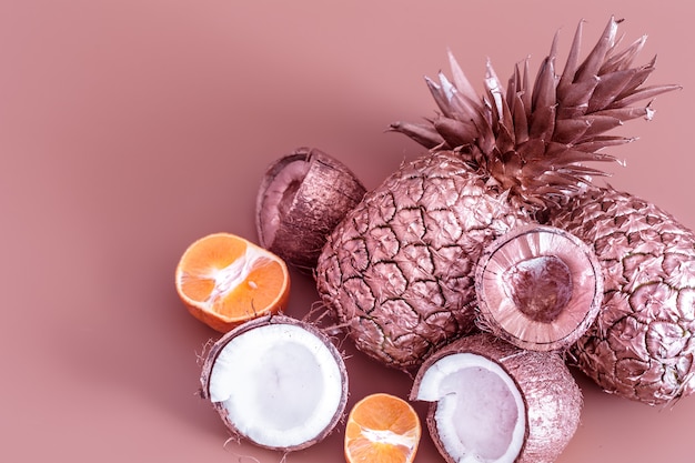 gold colored fruits on a colored background. Tropical flat lay. Food concept.