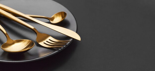 Gold cutlery set on black background