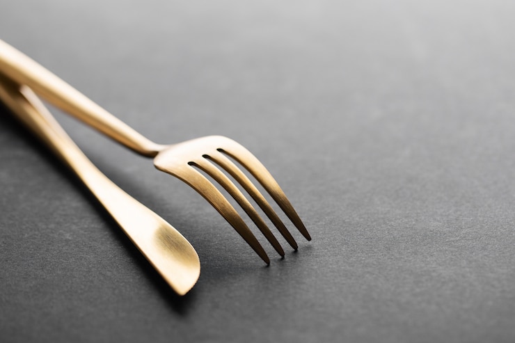 Free Photo gold cutlery set on black 