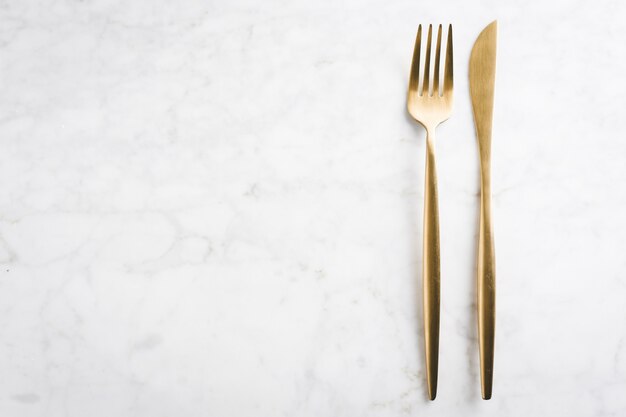 Gold cutlery set on marble 