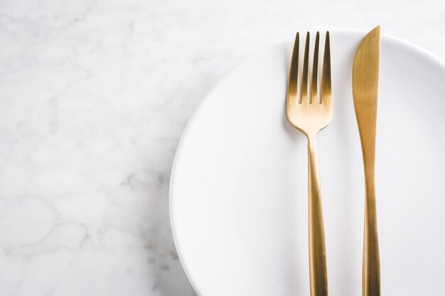 Gold cutlery set on marble 