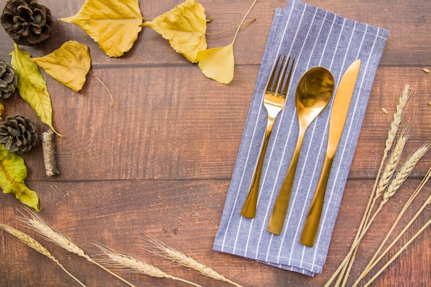 Gold cutlery set on napkin with leaflets