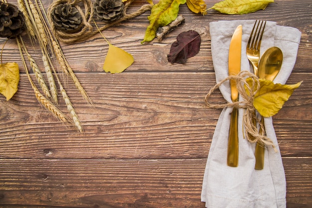 Gold cutlery set on table with leaflets