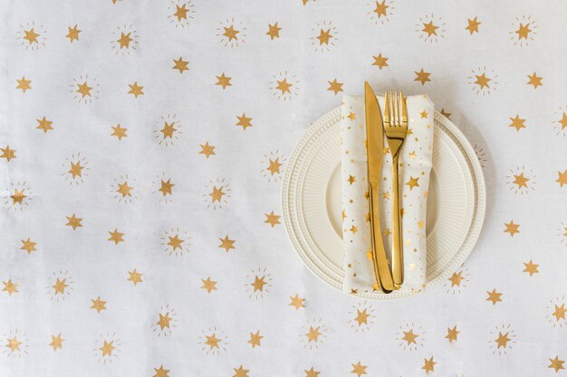 Free photo gold fork and knife on light plate