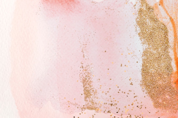 Free photo gold glitter on pink watercolor