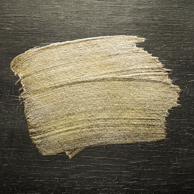 Текстура мазка кистью золотая масляная краска на цветном дереве