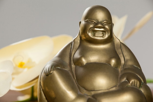 Free photo gold painted laughing buddha figurine