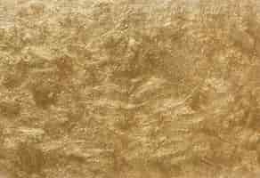 Free photo gold painted textured wall background