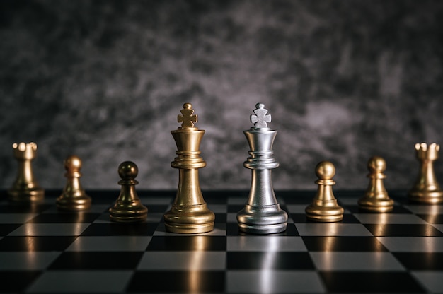 Free photo gold and silver chess on chess board game for business metaphor leadership concept