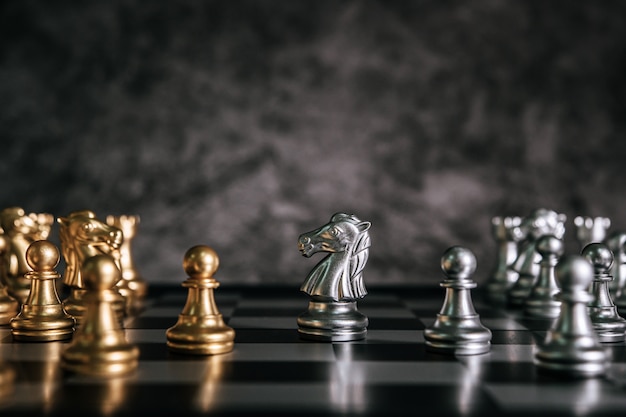 Foto gratuita scacchi dell'oro e dell'argento sul gioco di scacchiera per il concetto di direzione della metafora di affari