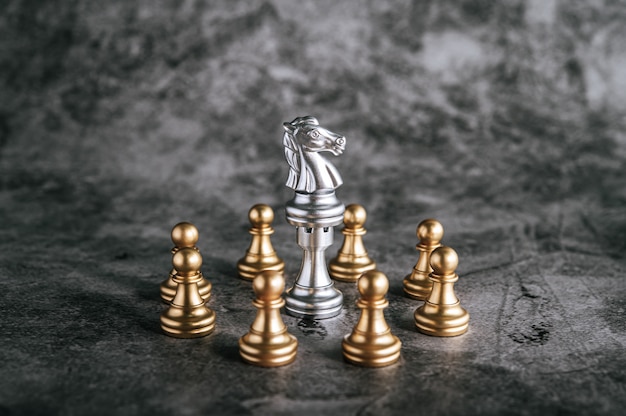 Free photo gold and silver chess on chess board game for business metaphor leadership concept