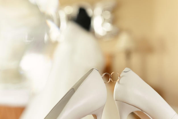 Gold wedding rings between the bride 's wedding shoes