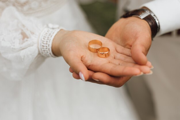 Golden bands in the hands of groom and bride