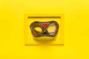 Foto gratuita maschera di carnevale d'oro in cornice gialla