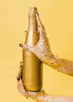 Free photo golden champagne bottle held in hands