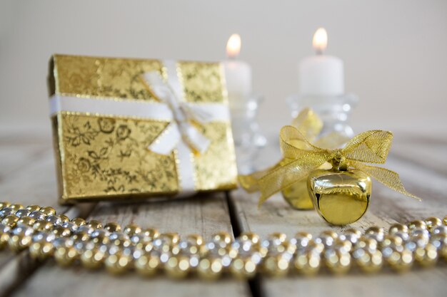 Золотой рождественские украшения на деревянный стол с подарком