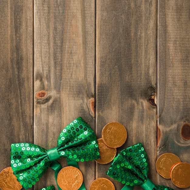 Free photo golden coins and bow ties on wooden board
