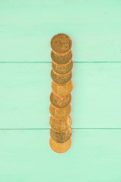 Free photo golden coins on wooden board