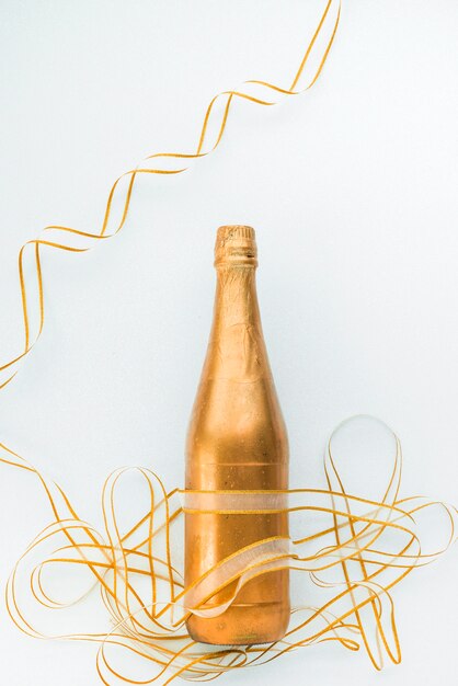 Free photo golden decorative bottle with ribbon around