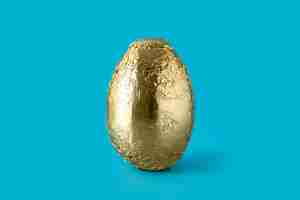 Free photo golden easter egg on blue background