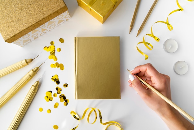 Golden elements with notebook and hand