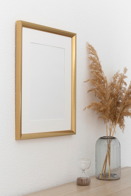 Golden frame on wall and ornamental plant