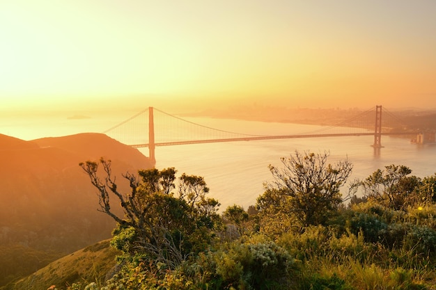 Golden Gate Bridge sunrise viewed from mountain top with San Francisco downtown