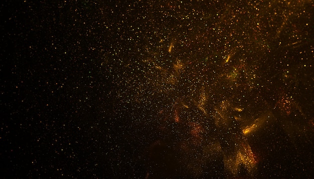 Gold flakes or golden dust on black background - abstract