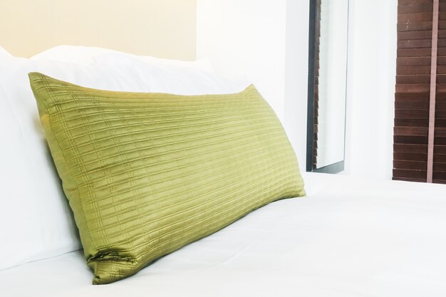 Golden pillow on the bed with white sheets
