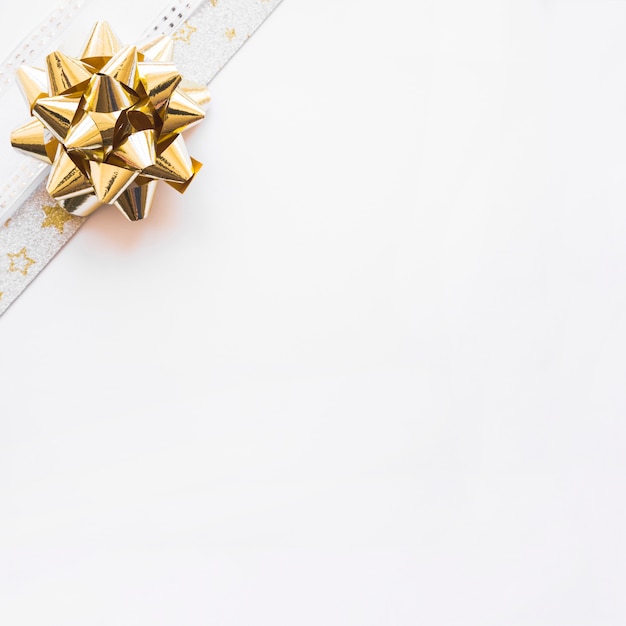 Golden ribbon bow on the corner of white background