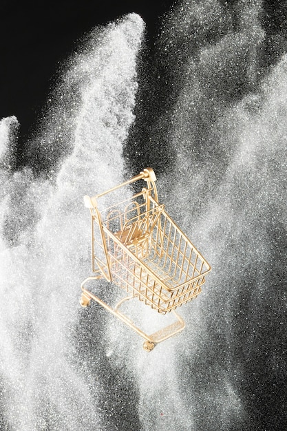 Free photo golden shopping cart in white glitter