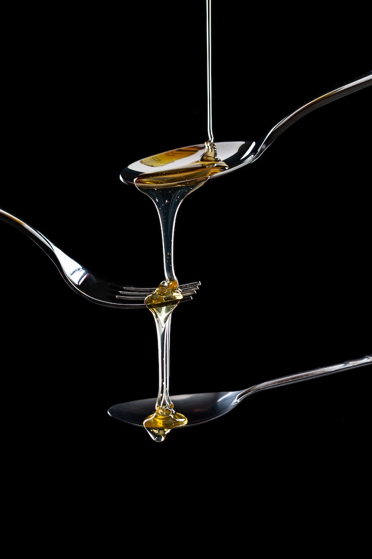Free Photo golden sweet honey dripping from spoon 