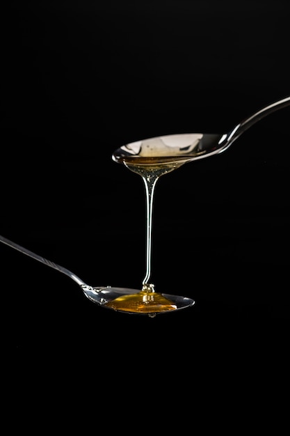 golden sweet honey dripping from spoon 