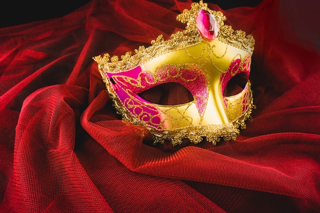 Golden venetian mask on a red fabric