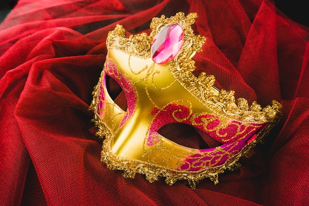 Maschera d'oro veneziano su un tessuto rosso