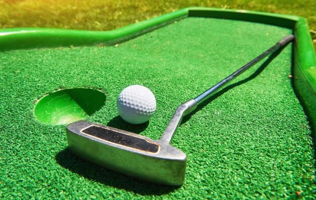 Golf ball and Golf Club on Artificial Grass.