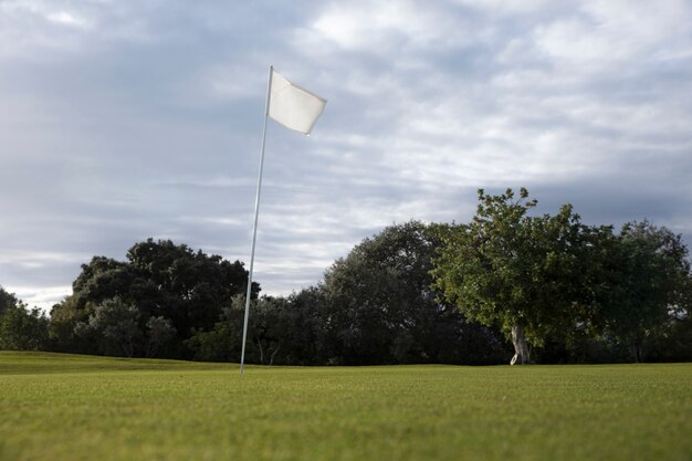 Golf flag waving on golf course ground