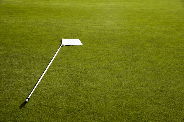 Golf flag waving on golf course ground