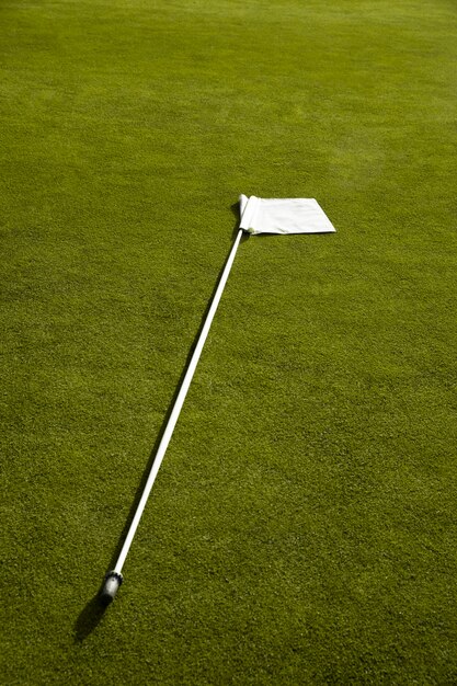 Golf flag waving on golf course ground