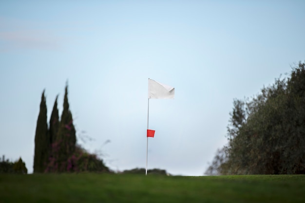 Golf flag waving on golf course ground