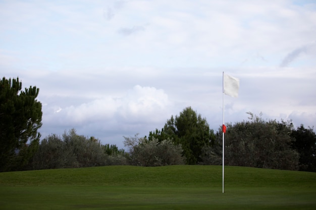 Golf flag waving on golf course ground