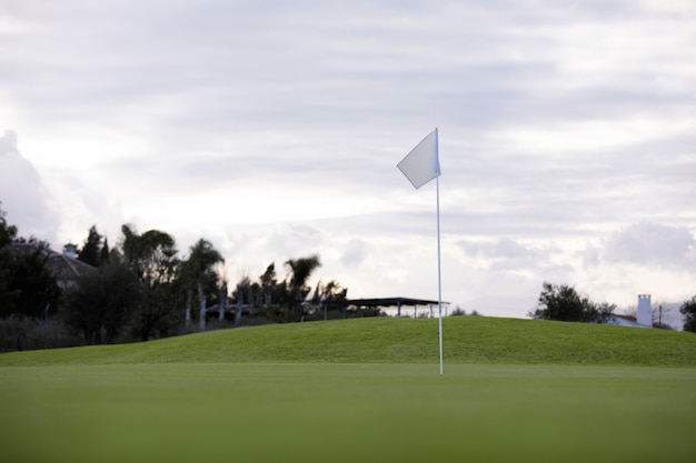 Golf flag waving on golf course ground