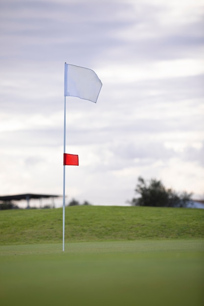 Golf flag waving on golf course ground