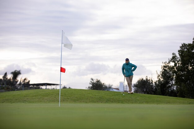 Golf flag waving on golf course ground