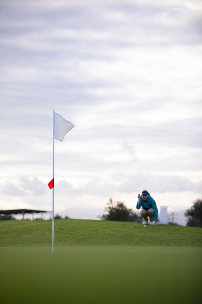 Golf flag waving on golf course ground