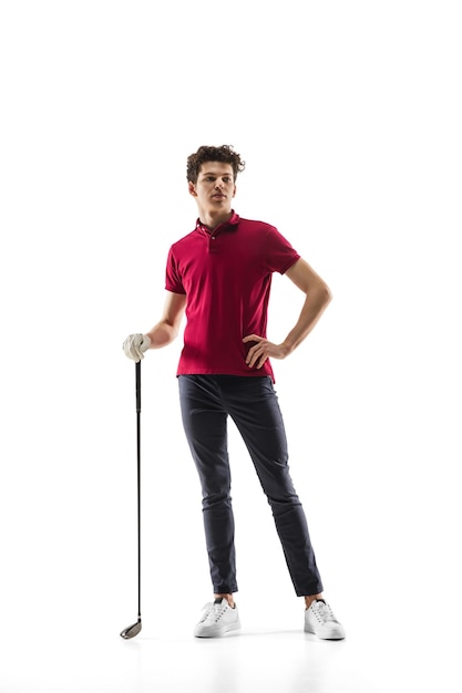 白いスタジオの背景に分離された練習の赤いシャツのトレーニングのゴルフプレーヤー