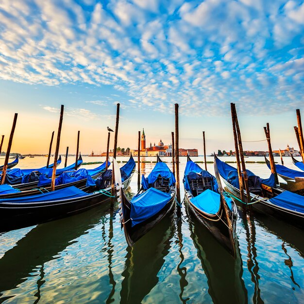 Гондолы в лагуне Венеции на восходе солнца, Италия